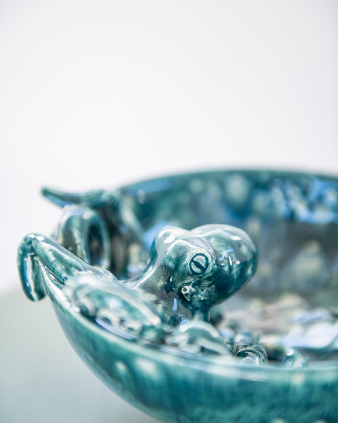 Teal ceramic bowl with a frog design on a white background