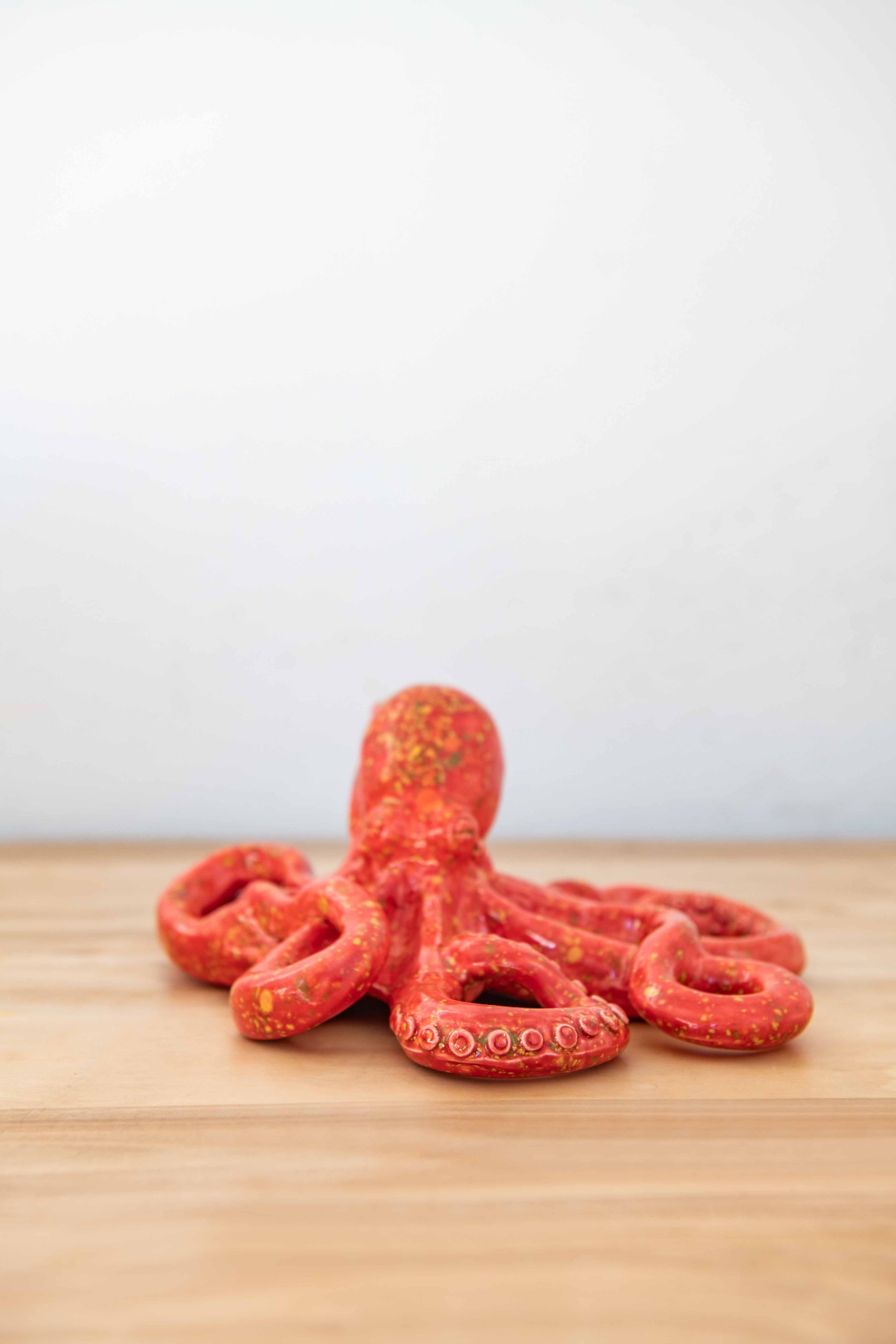 Rialheim ceramic Octopus on a table on white back ground in red lave crystal Glaze