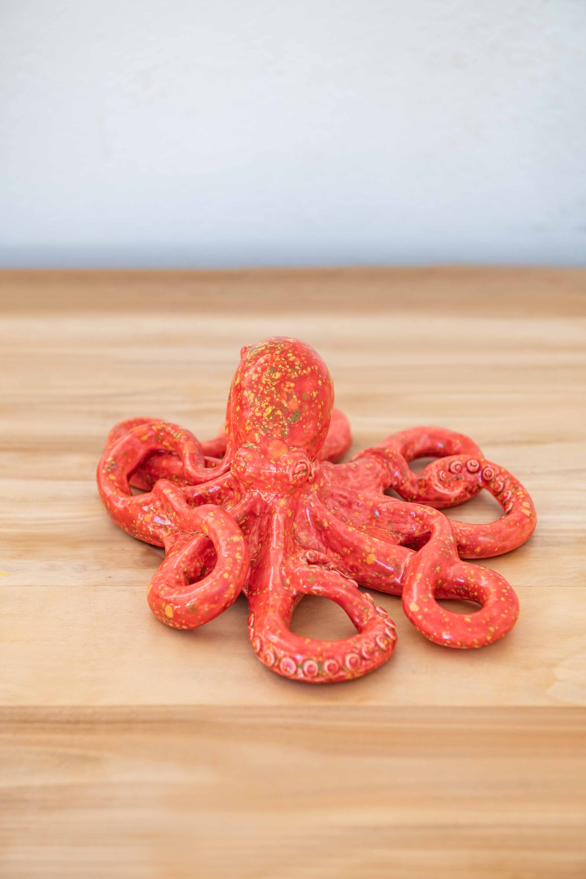 Rialheim ceramic Octopus on a table on white back ground in red lave crystal Glaze