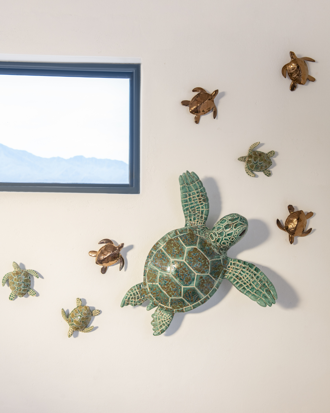 Decorative turtle wall art on a light-colored wall with a framed picture.