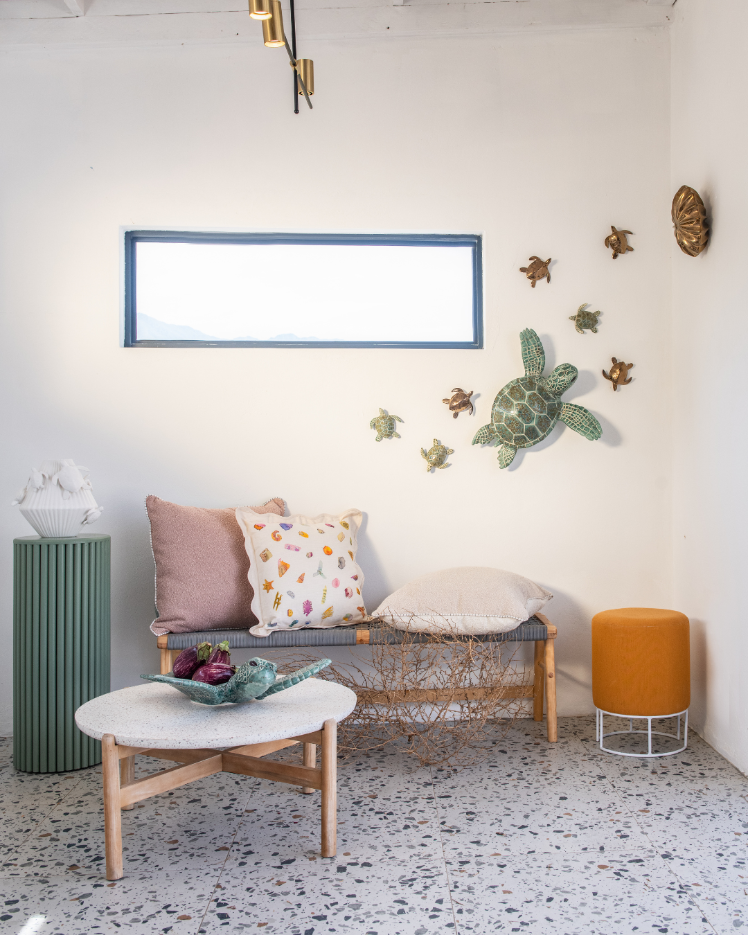Decorative large and Small ceramic Sea Turtles mounted against the wall in a Modern living room with a sofa, and coffee table