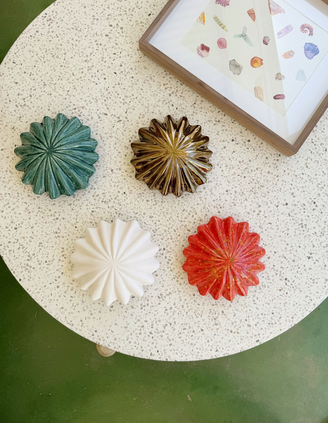 Decorative items on a textured surface with a framed picture in the background