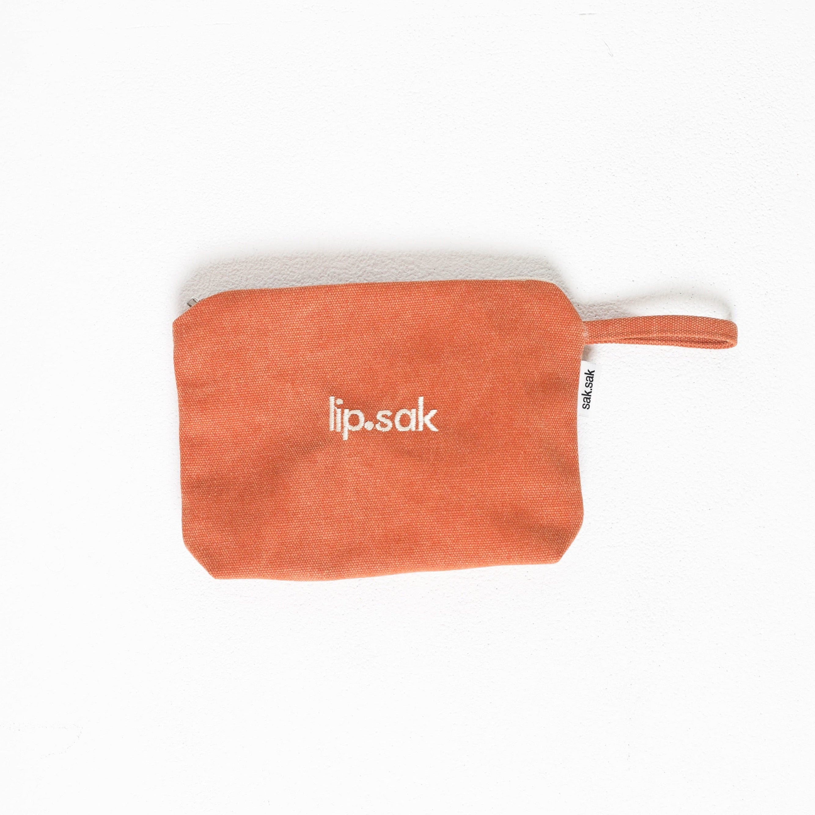 Orange pouch with 'lip.sak' branding on a white background