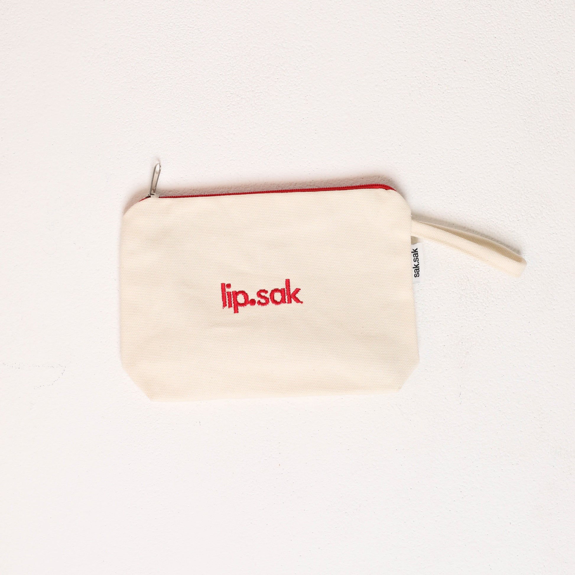 Small beige pouch with 'lip.sak' logo on a white background