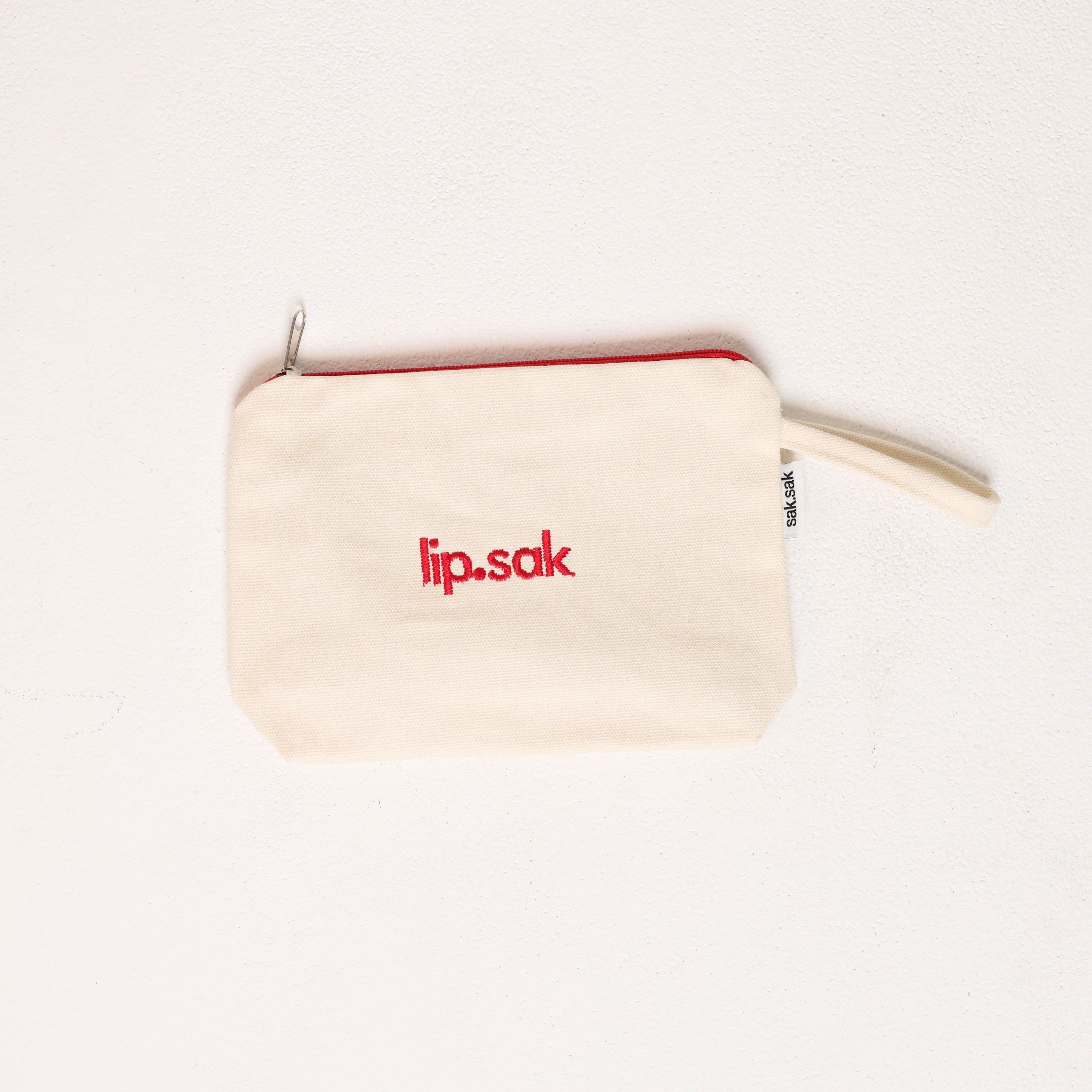 Small beige pouch with 'lip.sak' logo on a white background