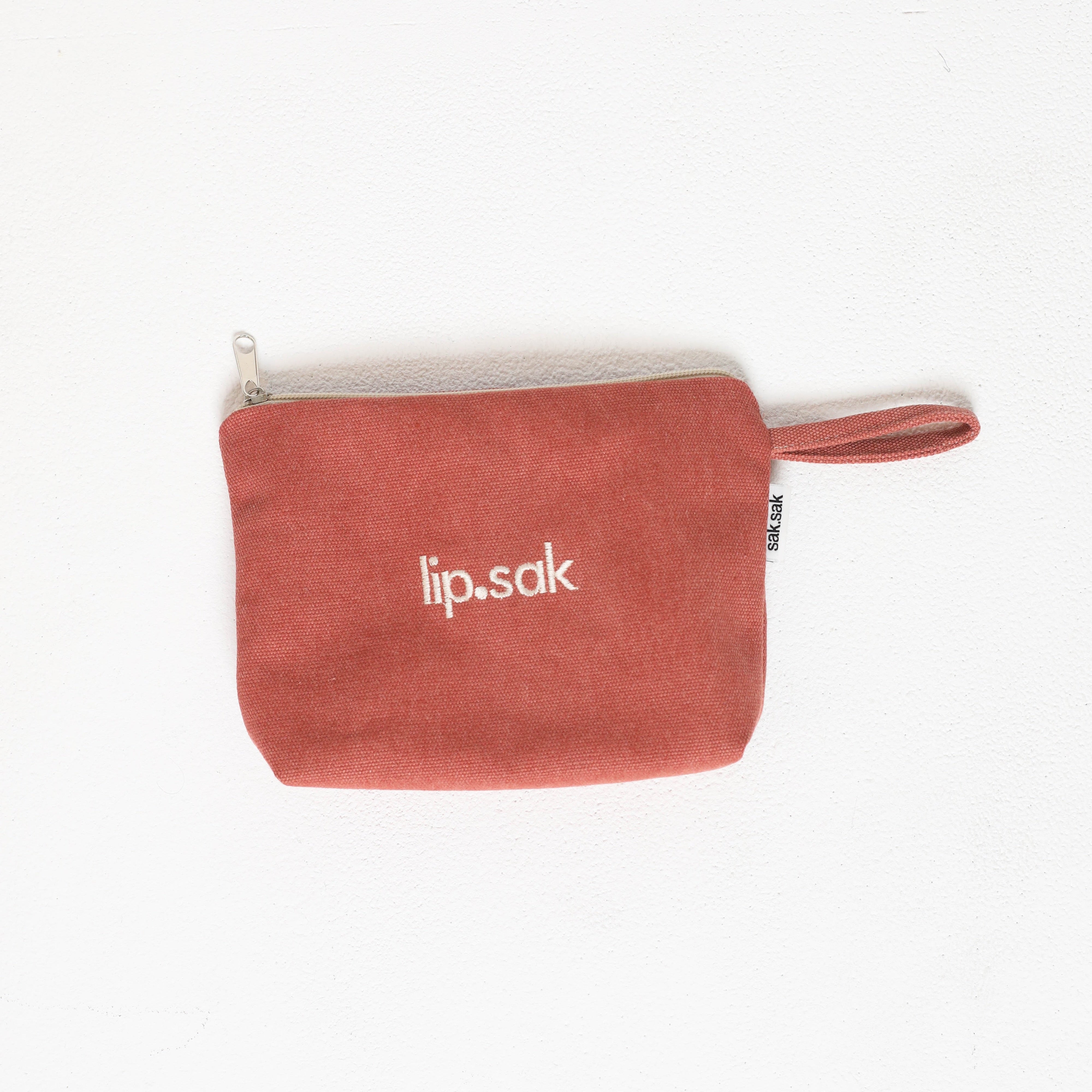Red pouch with 'lip.sak' branding on a white background