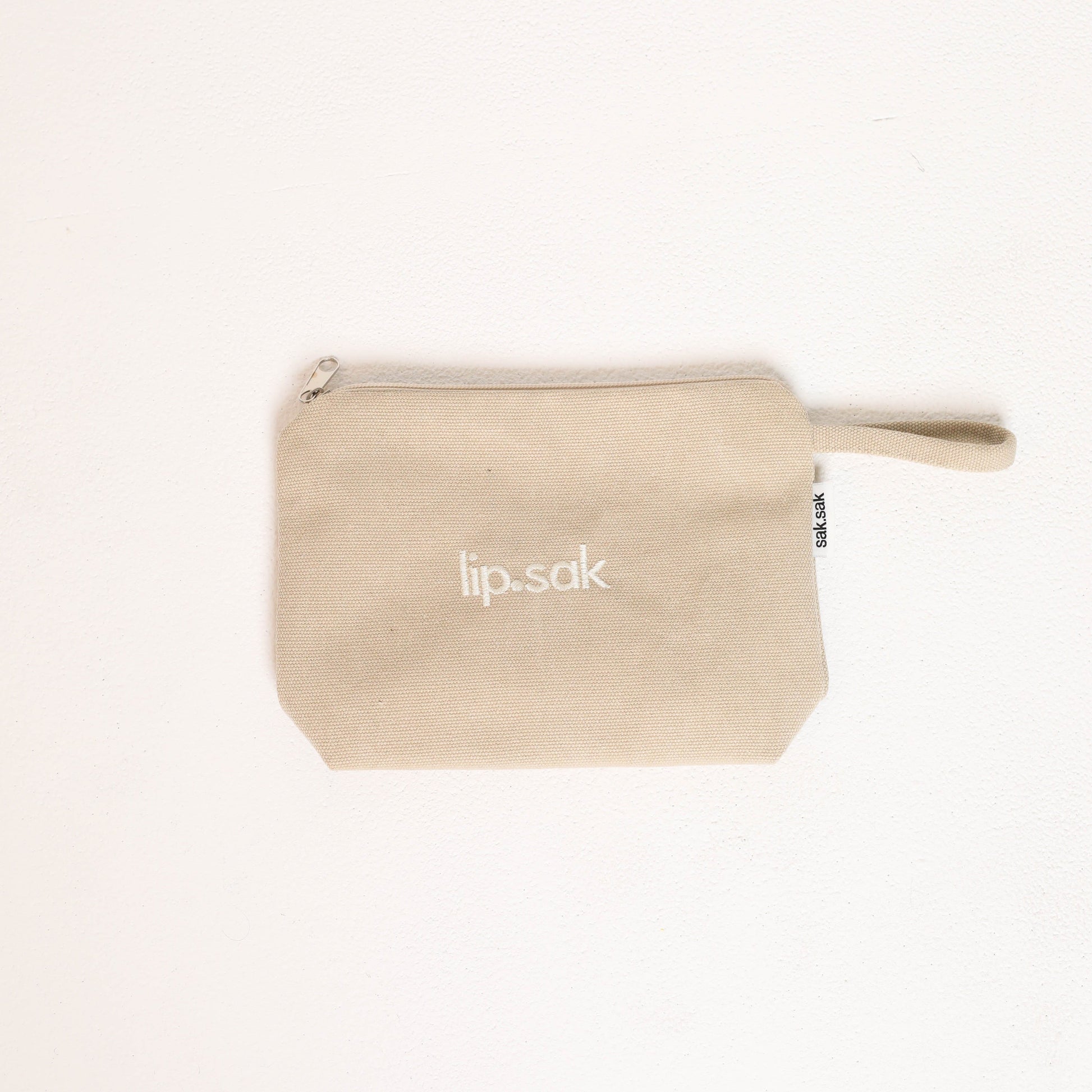 Cream pouch with 'lip-sak' branding on a white background