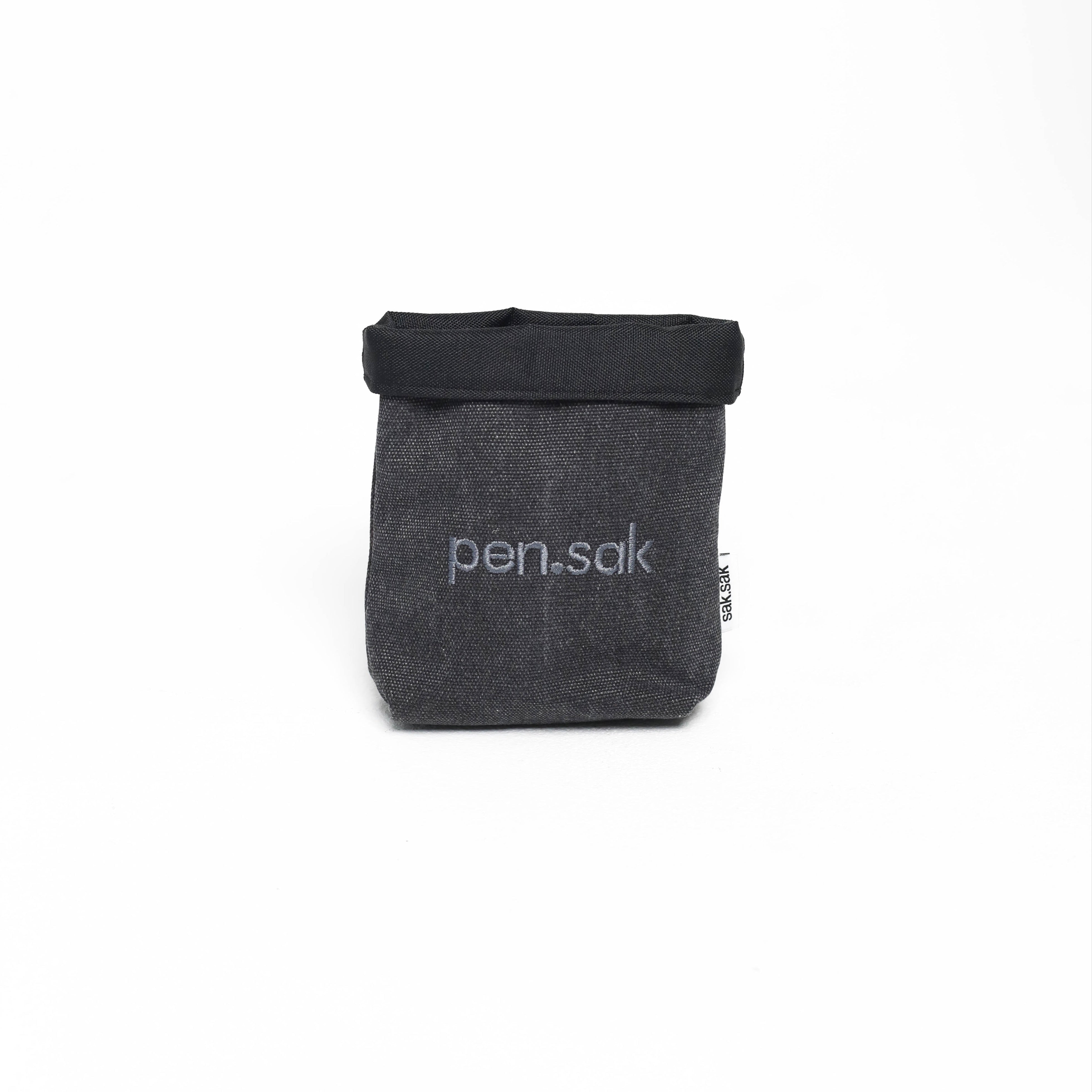 Black fabric pouch with 'pen.sak' branding on a white background