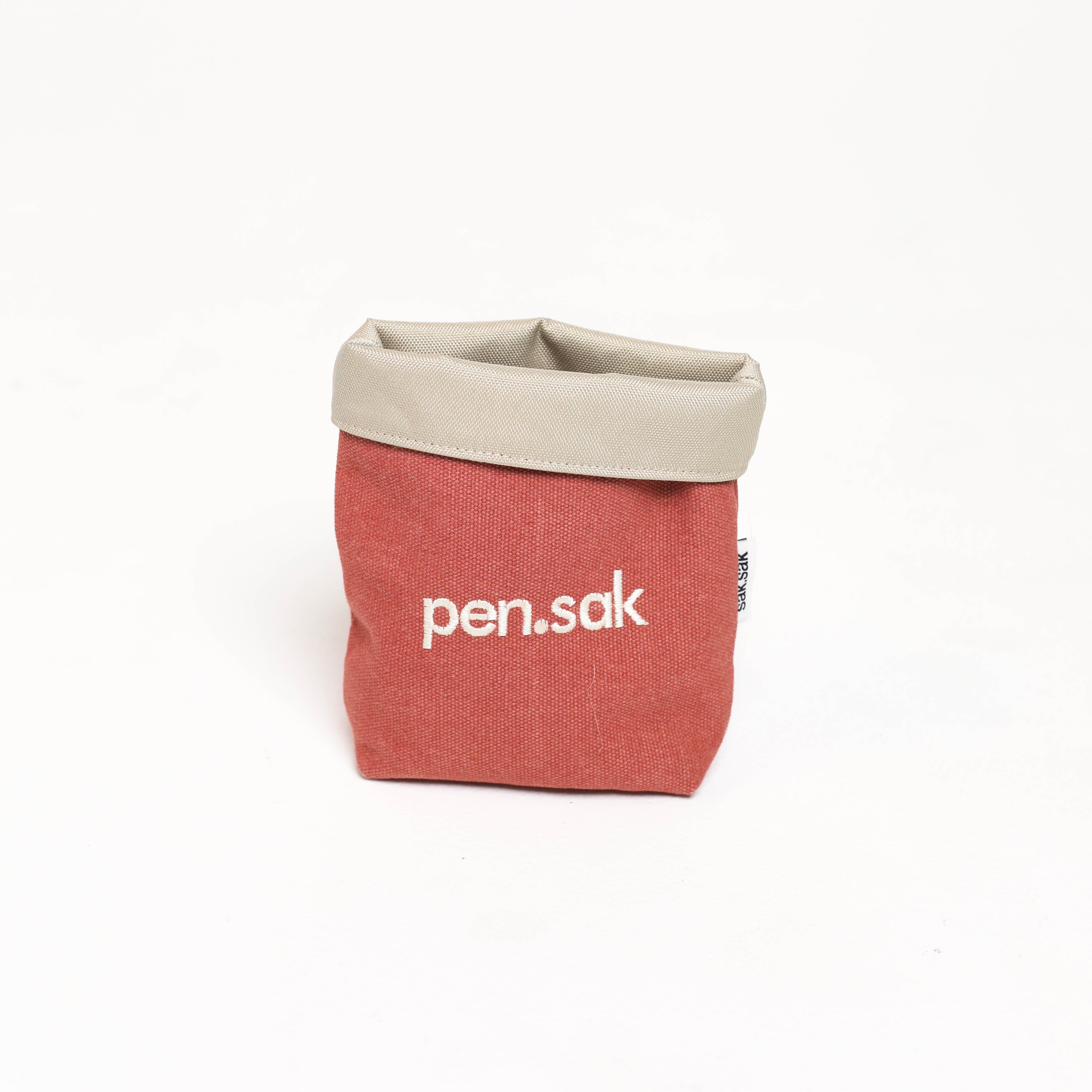 Red and beige 'pen.sak' bag on a white background
