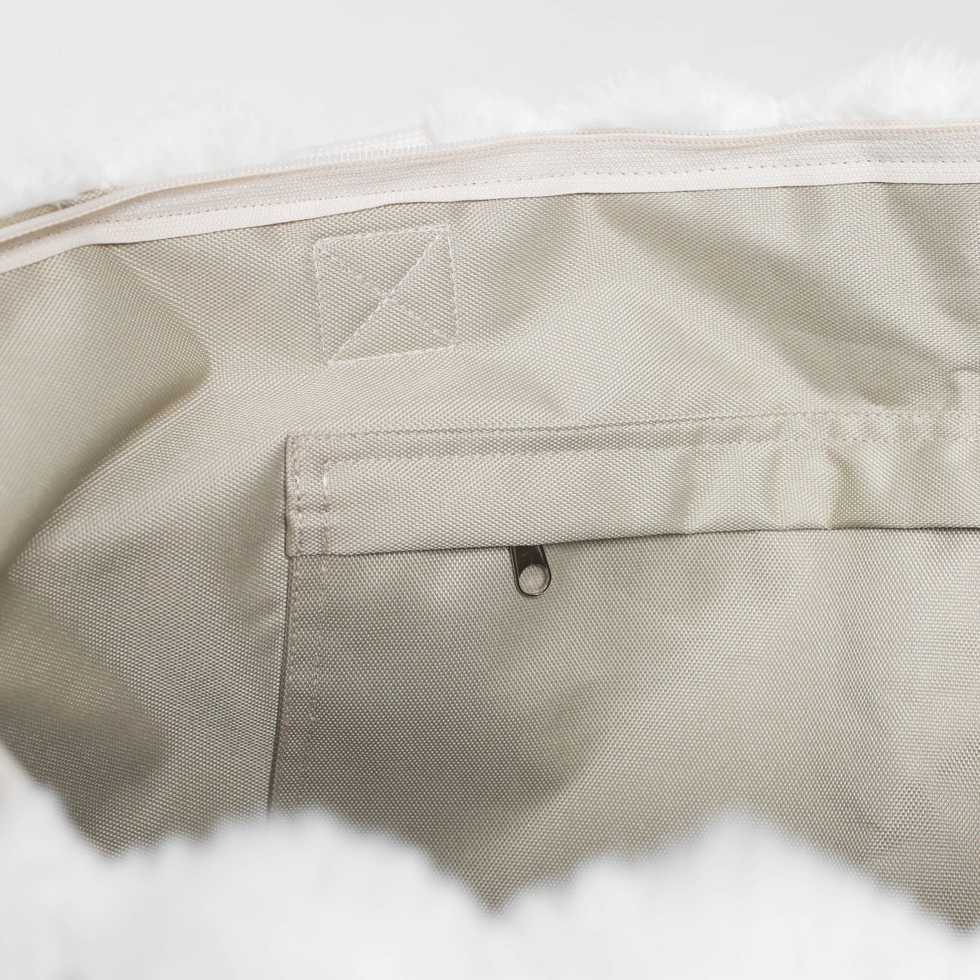 Close-up of beige fabric with a brand logo on a white background