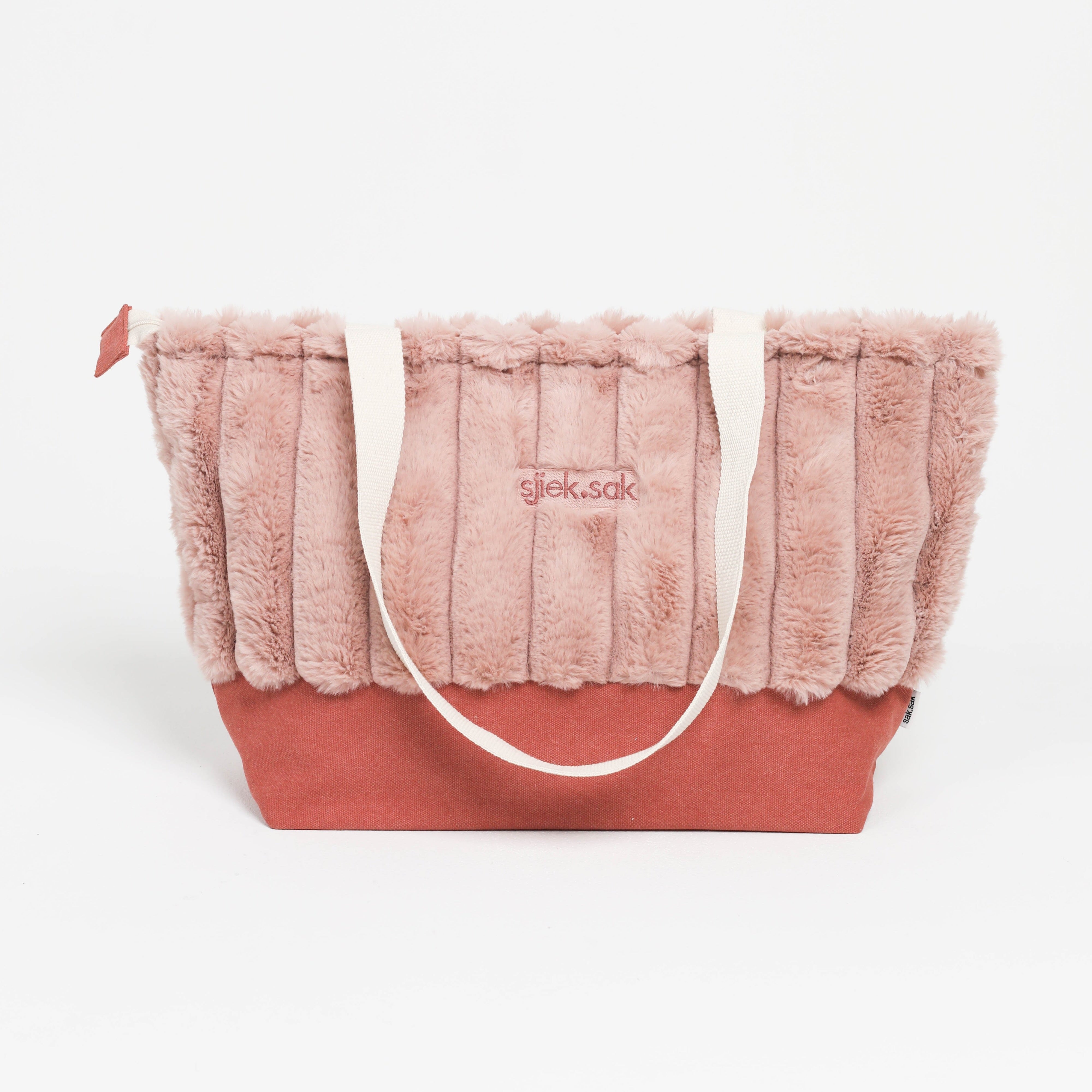 Pink plush tote bag with a visible brand logo on a white background